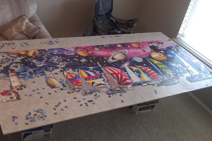 At Victor’s house, the right half of the puzzle is almost complete.  The puzzle depicts an abstract scene  with sailboats and planetary bodies in space. Photo courtest of Ryan Victor