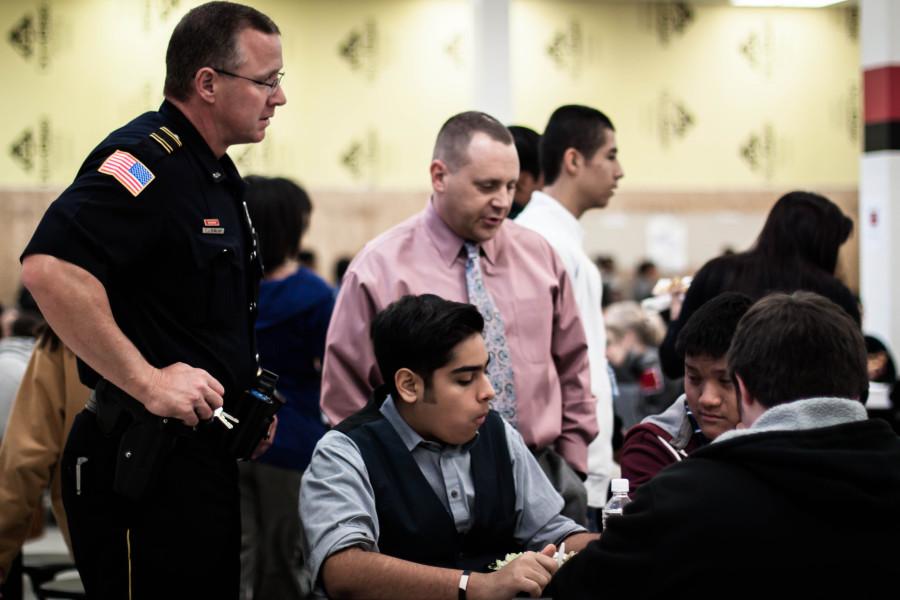 Student Resources Officer T.J. Bomkamp and Principal Dan Cummings approach sophomores Abraham Khan and David Phan and join their conversation.