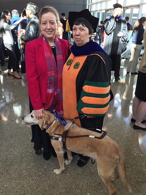 At UTD’s doctoral graduation in December, Dr. Marilyn Bland poses with her daughter, Juliet Bond, and her guide dog, Honey. photo courtesy of Ruth Martin